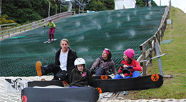 Snowboarders sitting with skier in background
